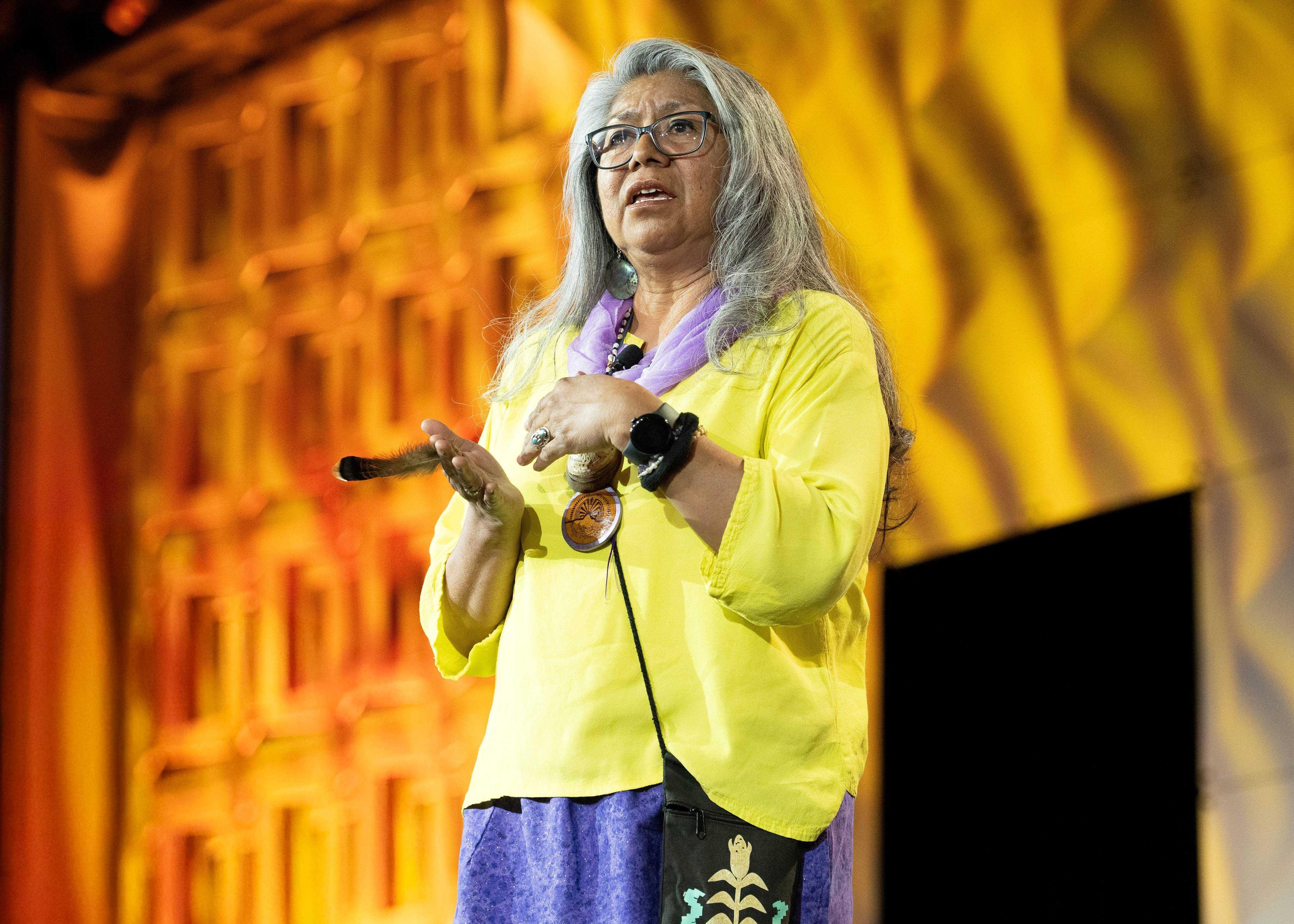 A woman speaking on stage.