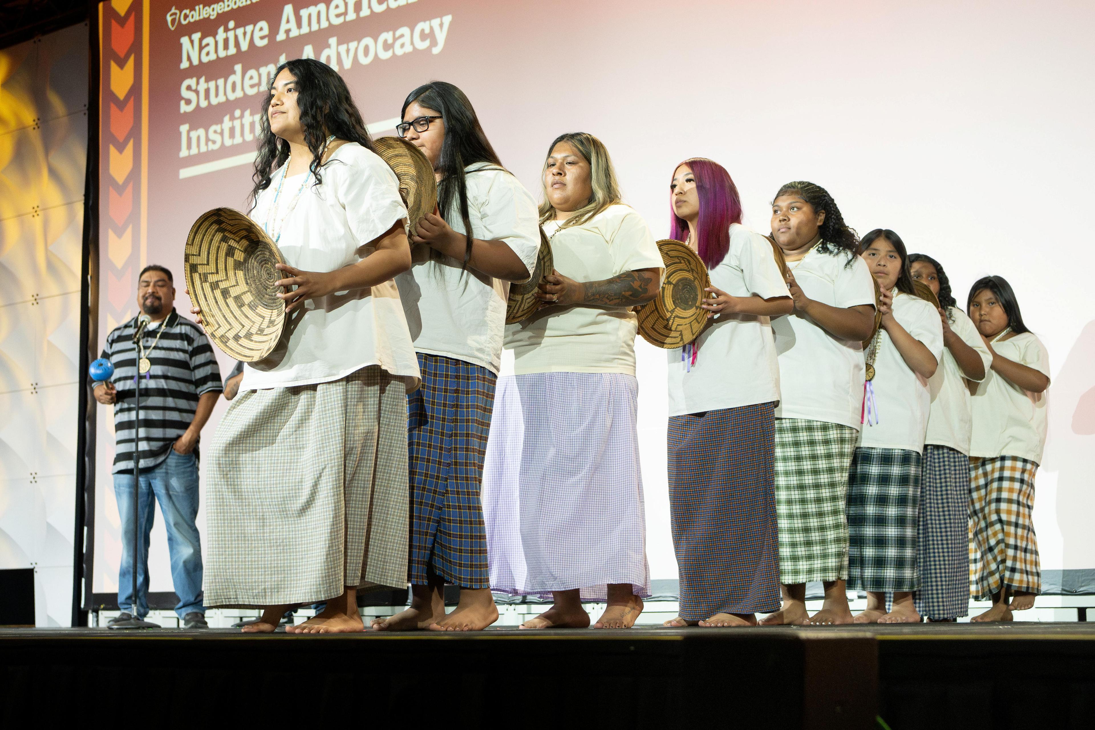 A group of dancers performing with baskets.