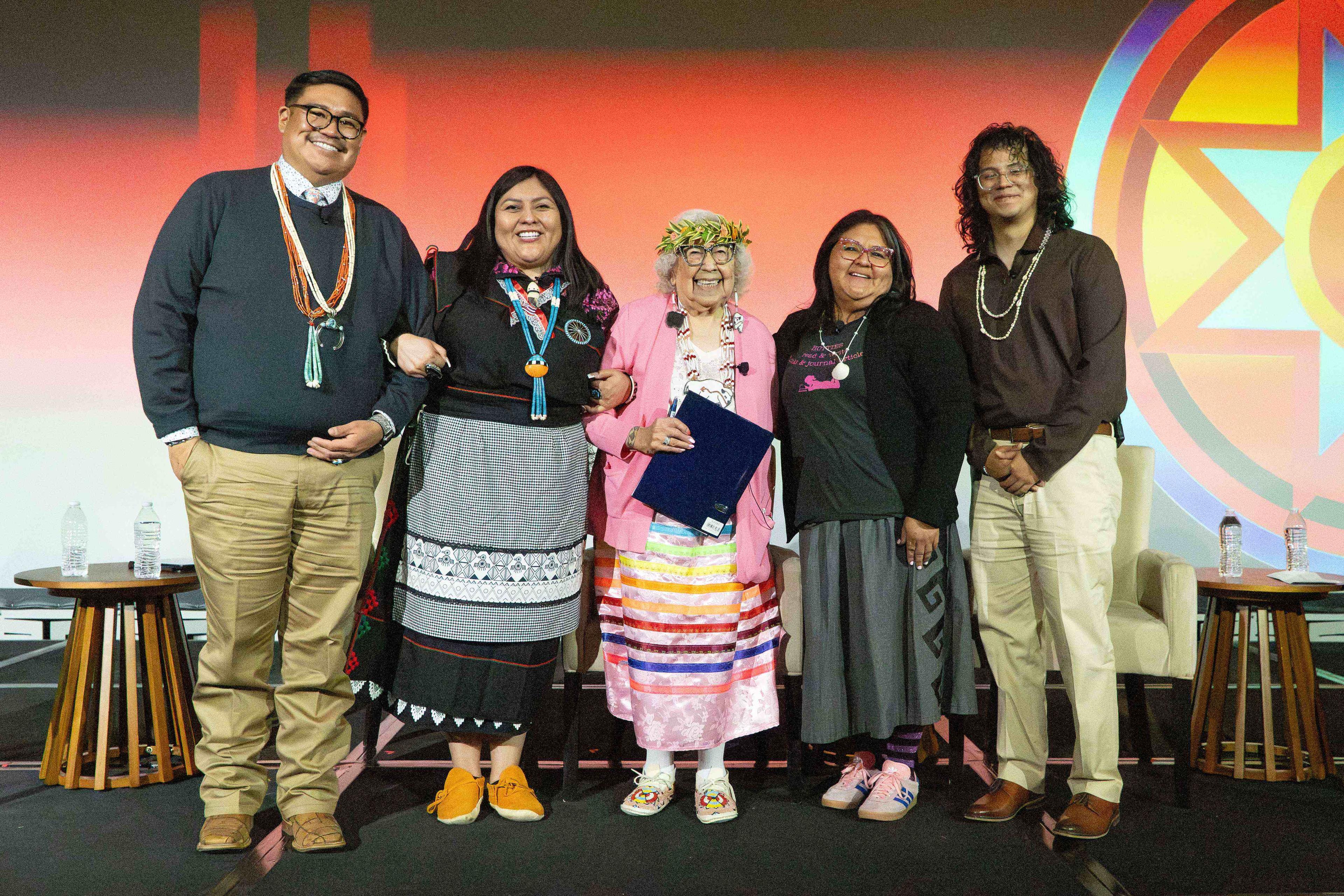 A group on stage posing for a photo.