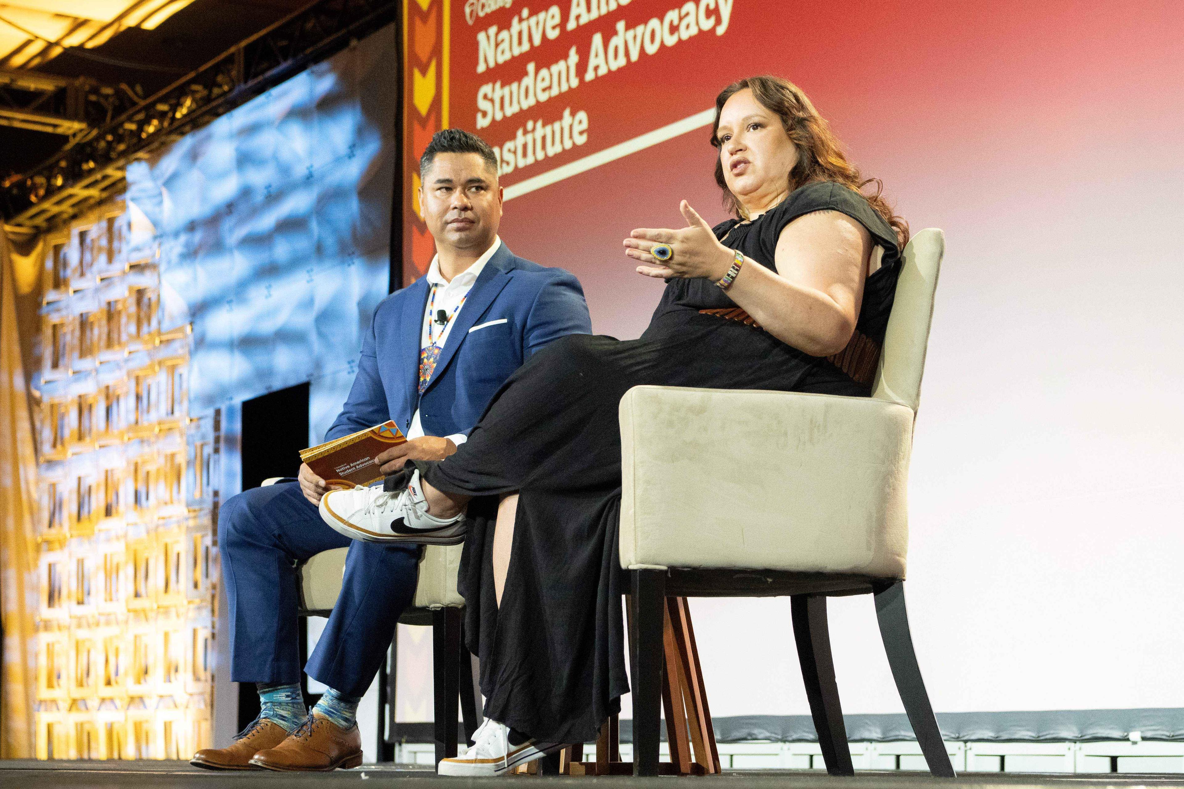 A man and woman on stage having a conversation.