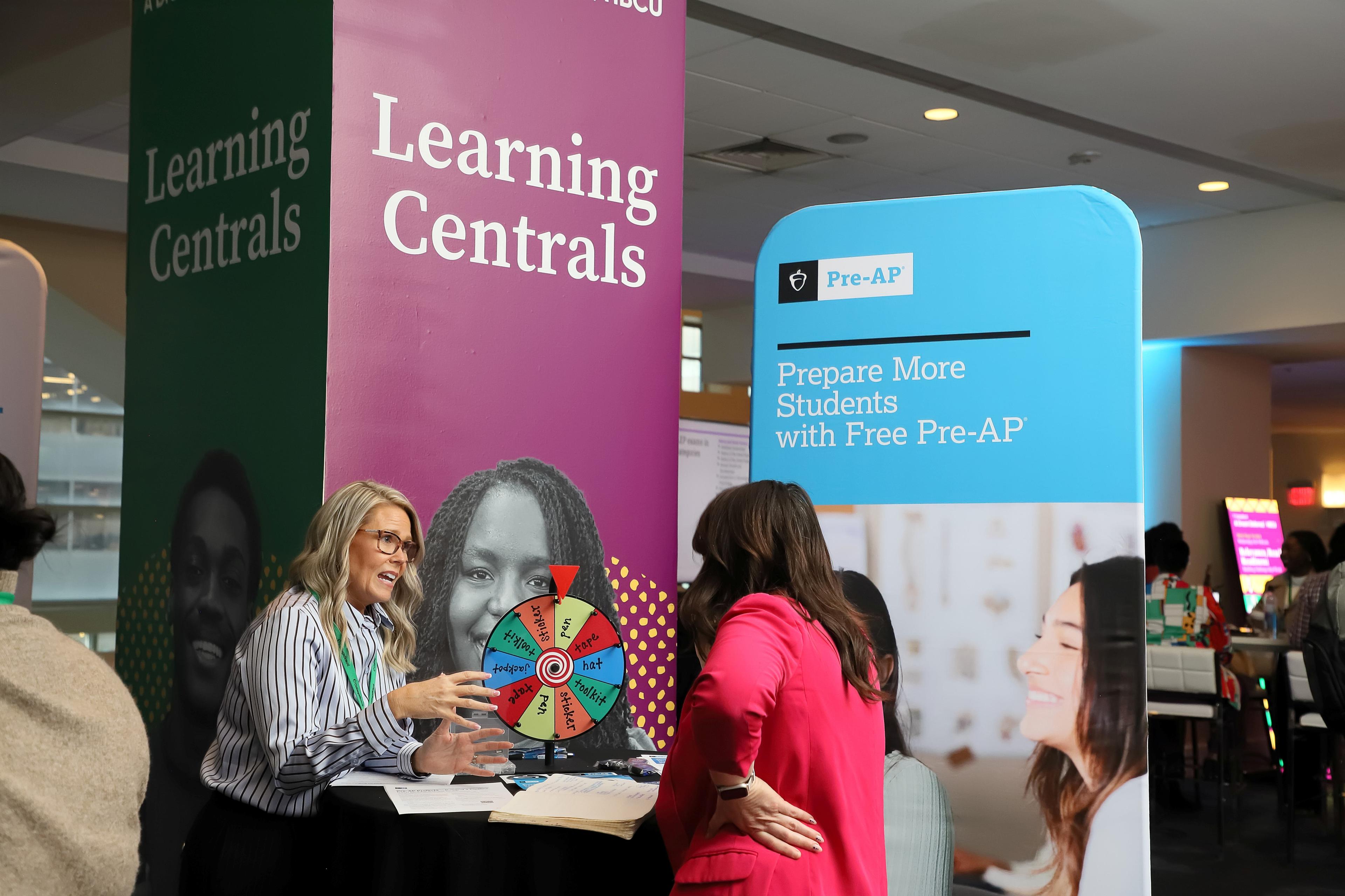 An attendee meeting with College Board staff at a booth.