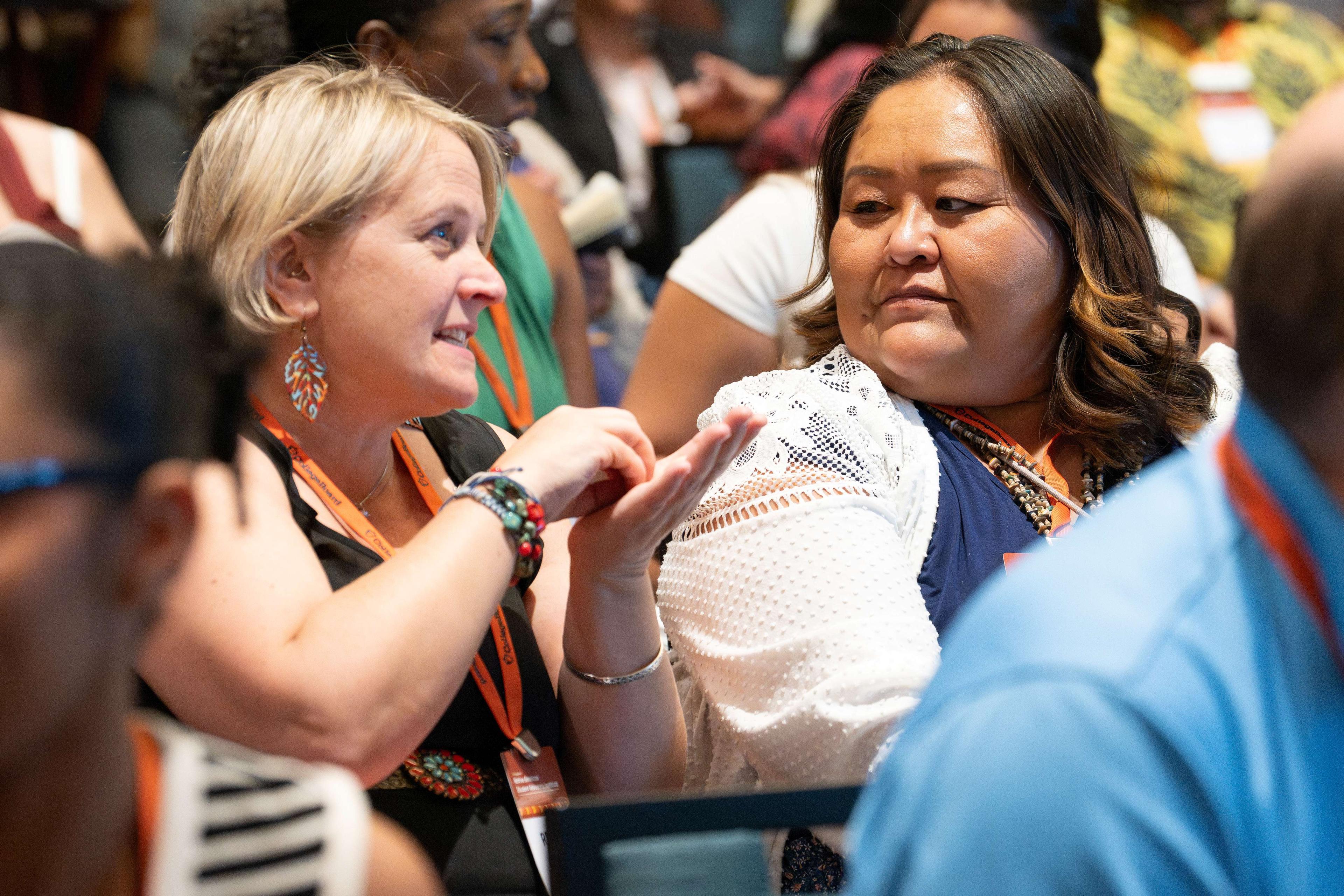 Two women having a discussion in the audience.